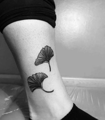 小腿处两片黑色元素的银杏叶纹身图片