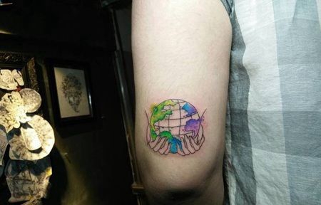胳膊肘双手托着地球的水彩纹身图片