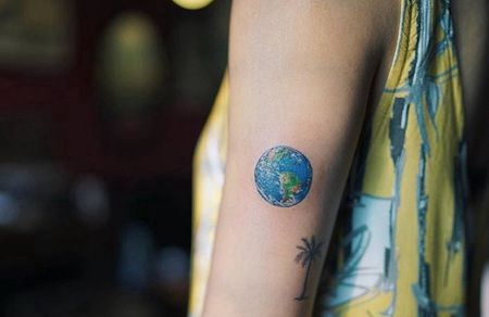 手臂上小型地球和椰子树纹身图案
