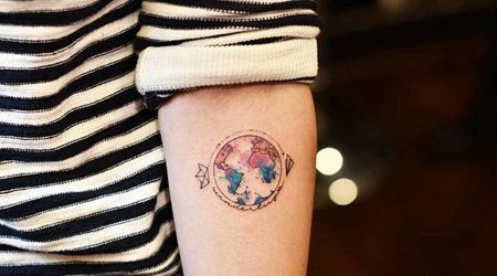 纸飞机和纸船绕地球运行的纹身图案