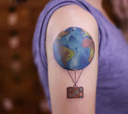 胳膊上彩色的地球和手提箱纹身图案