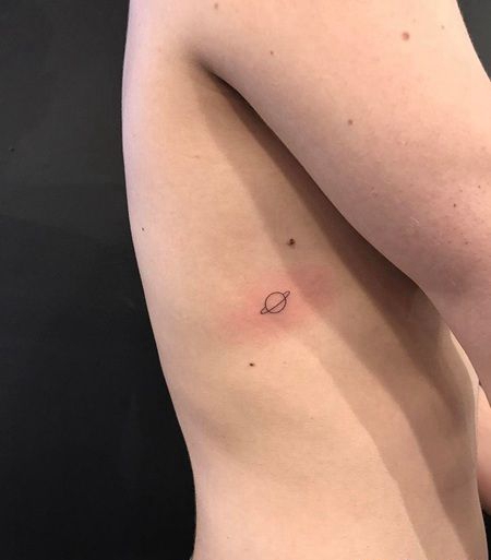 女士肋骨处纹了一个线条星球图案