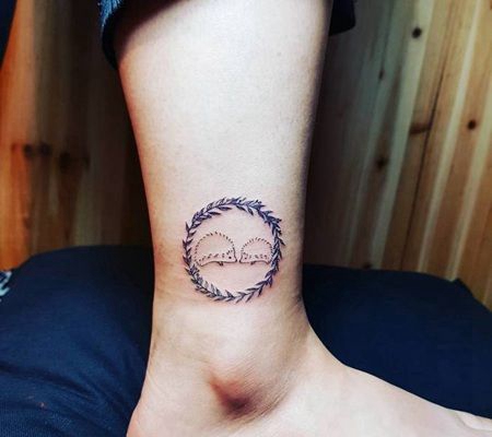 两只可爱的小词汇在一个由树叶组成的圆圈纹身图案