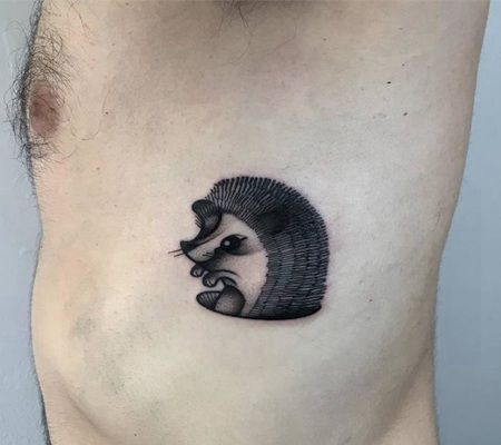 肋骨部位黑色刺猬钻出洞露个上半身纹身图片