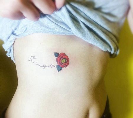 美女肋骨部位纹了一朵创意的红色花朵与英文字母花枝纹身