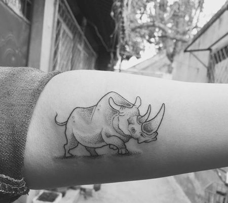 肱二头肌部位一头正在奔跑的素描犀牛纹身图片