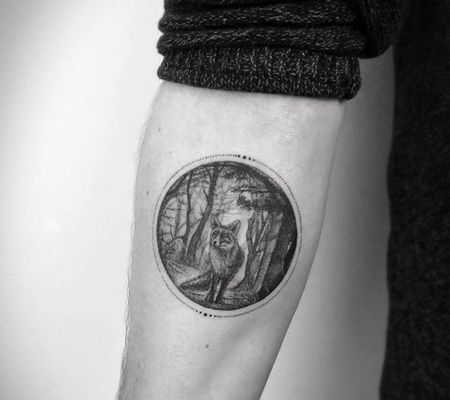 一只在黑白色圆形森林景观里行走的纹身图案