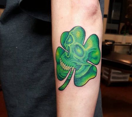 男子手臂上骷髅头形状的四叶草纹身图片