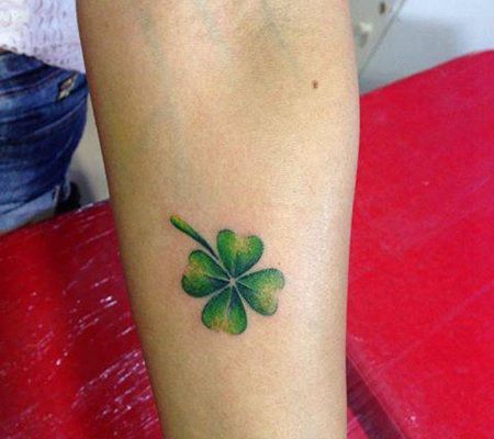 手臂上一个有点枯萎的四叶草纹身图片