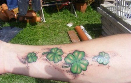 手臂上四个大小不等的四叶草的3D纹身图片