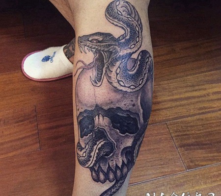 腿部气势凶猛的蛇和骷髅纹身