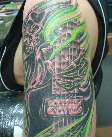 大臂上弹吉他的骷髅纹身图案
