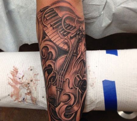 小臂上的吉他钢琴键纹身图案