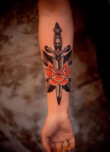 手臂刺穿玫瑰的匕首纹身图案