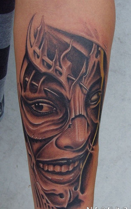 小臂上的扭曲人像纹身