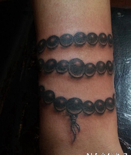 手腕上的黑灰佛珠纹身