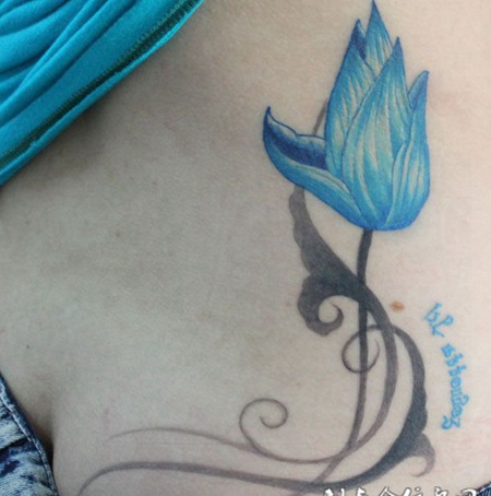 腰侧蓝色的莲花纹身