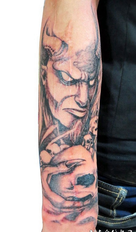胳膊上抱着骷髅的恶魔纹身