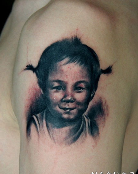 胳膊上的娃娃头像纹身