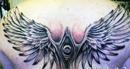 后背上长着翅膀的眼睛纹身