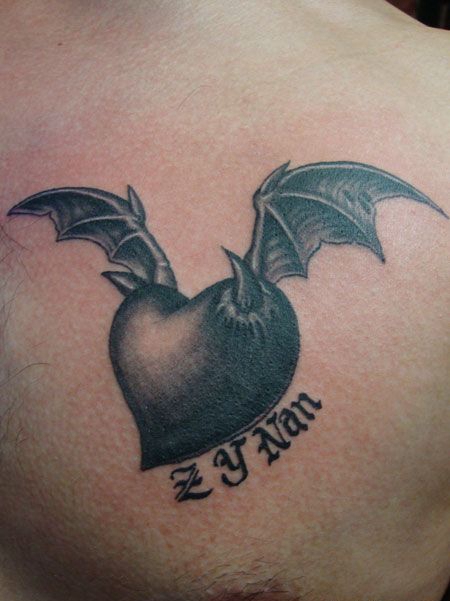 胸部长着恶魔翅膀的心纹身图案
