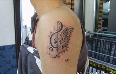 大臂上的乐符翅膀纹身