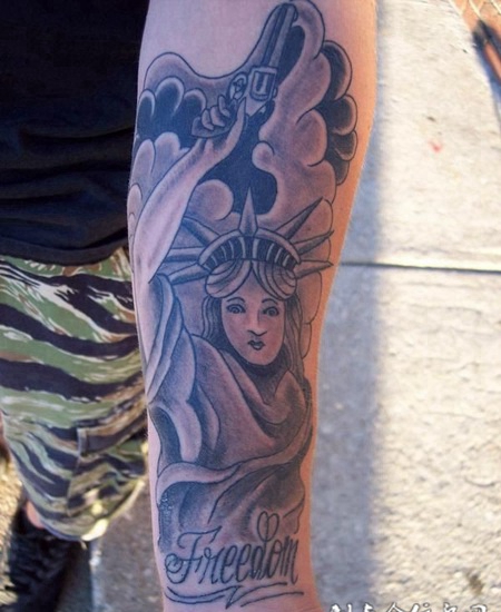 小臂上拿着手枪的女神纹身图案