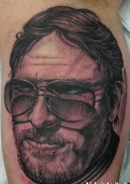 大臂上带着墨镜的大胡子纹身图案