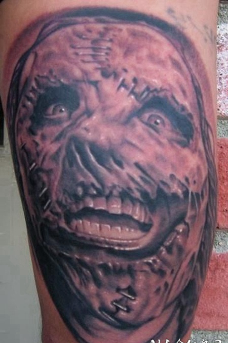 大臂上的缝补的恶魔纹身图案