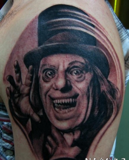 大臂上的咧嘴大笑的恶魔纹身图案