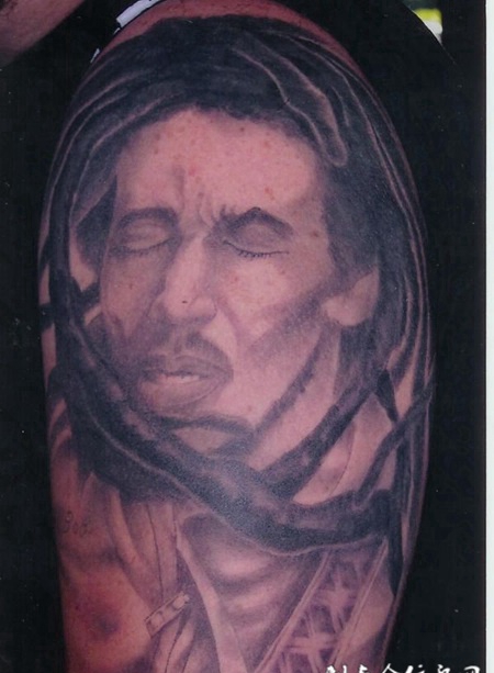 大臂上的被树枝缠绕的男子纹身图案