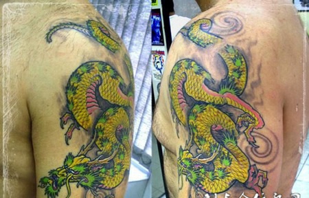 大臂上的一条绿色的龙纹身图案