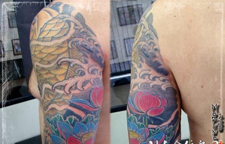 大臂上的金色鲤鱼莲花纹身图案