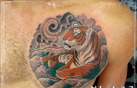 胸前一只老虎趴在岩石上的纹身图案