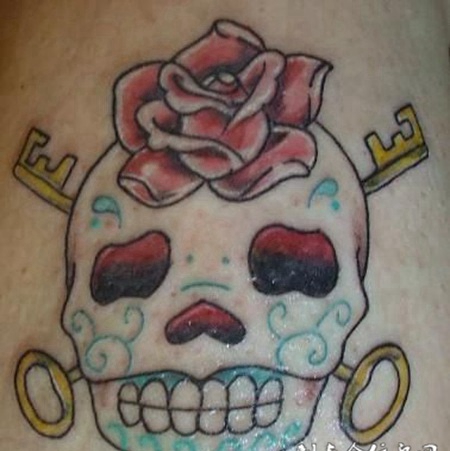 大臂上的花面骷髅与玫瑰纹身图案