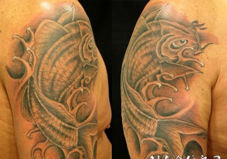 大臂上一条鲤鱼在浪花中的纹身图案