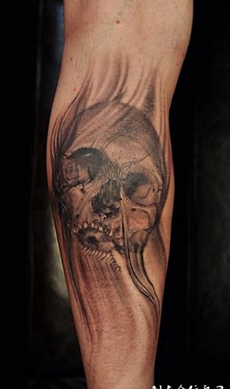 小臂上风化的骷髅头纹身图案