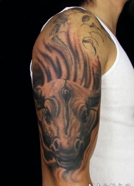 大臂上的三眼马面纹身图案