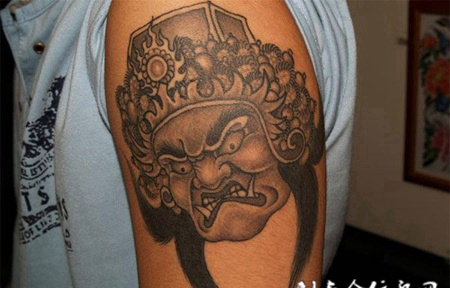 大臂上的不动明王头像纹身图案