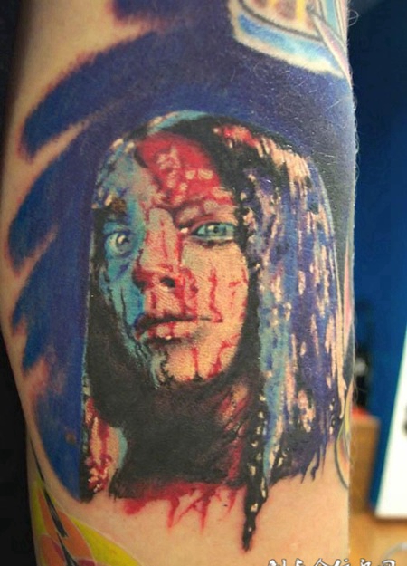 大臂上满脸血迹的女士纹身图案