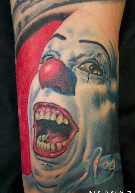 大臂上长着红鼻子的小丑纹身图案