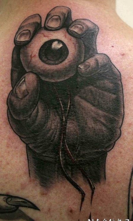 后背上拿着眼睛的手纹身图案