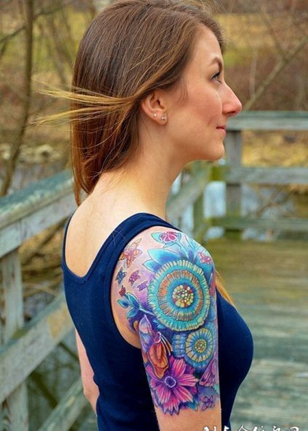 大臂上的彩色雏菊纹身图案