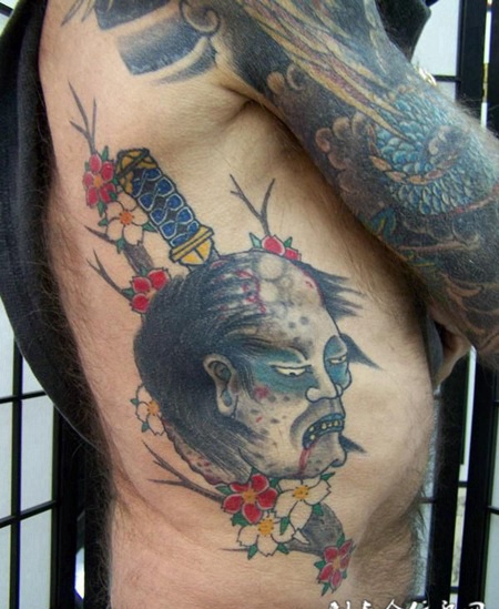 腰侧的生首匕首纹身图案