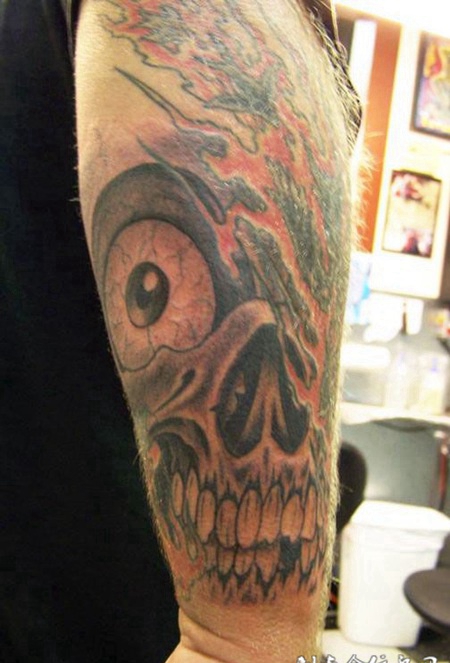 大臂上带着火焰的骷髅头纹身图案
