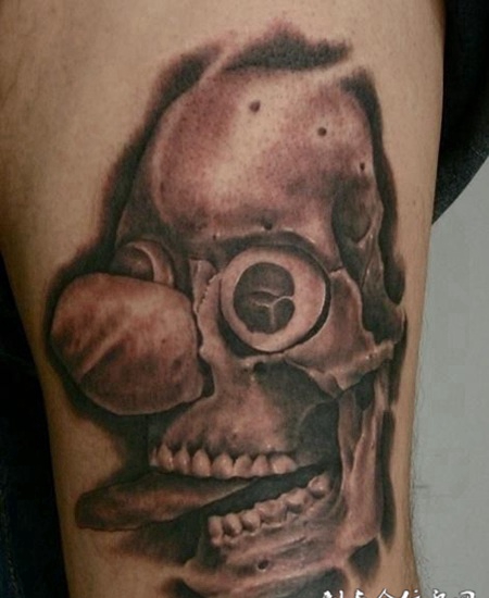 大臂上的雕刻娃娃纹身图案