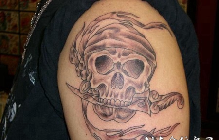 大臂上叼着匕首的骷髅头纹身图案