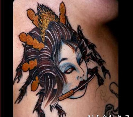 大臂上叼着匕首的生首纹身图案