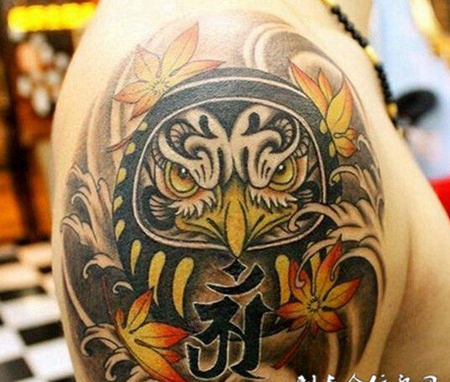 大臂上的枫叶不倒翁纹身图案