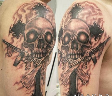 大臂上的骷髅手枪纹身图案